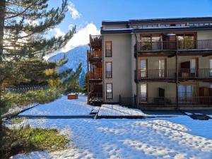 a snow covered road in front of a building at Hostdomus - Sansicario R19 in Cesana Torinese