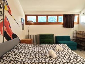 a bedroom with a bed and a blue chair at Hostdomus - Sansicario R19 in Cesana Torinese