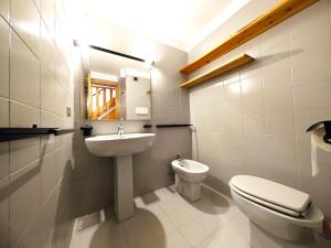 y baño con lavabo, aseo y espejo. en Hostdomus - Sansicario R19, en Cesana Torinese
