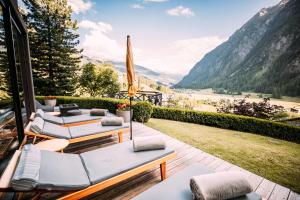 a patio with a view of a valley and mountains at Nationalpark Lodge Grossglockner in Heiligenblut