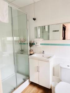 a white bathroom with a shower and a sink at The Boho - 4 min walk to beach & town in Bournemouth