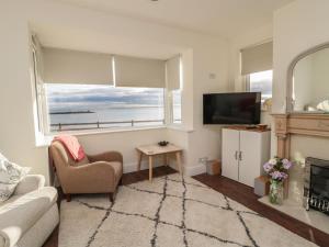 a living room with a couch and a television at Fairwinds in Newbiggin-by-the-Sea