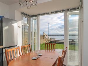 a dining room with a table and a view of the ocean at Fairwinds in Newbiggin-by-the-Sea