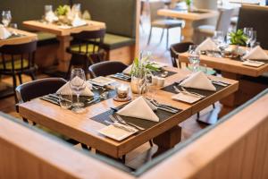 a wooden table with napkins and glasses on it in a restaurant at Nationalpark Lodge Grossglockner in Heiligenblut