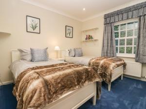 two beds in a room with a window at Lakeside View in Ulverston