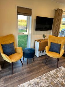 a living room with two chairs and a tv at South Black Hill in Penicuik