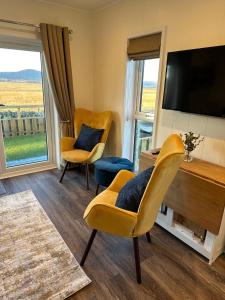 a living room with two chairs and a flat screen tv at South Black Hill in Penicuik