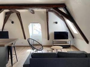 a living room with a couch and a tv at Vue sur la cathédrale - Au cœur de Bourges in Bourges
