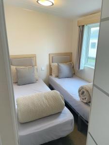 a room with two beds and a window at 3 bedroom luxury caravan haven, marton mere in Blackpool