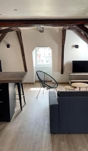 a living room with a couch and a table at Vue sur la cathédrale - Au cœur de Bourges in Bourges