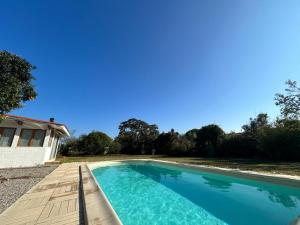 una piscina con una pasarela de madera junto a una casa en Maison Elne, 5 pièces, 10 personnes - FR-1-732-60 en Elne