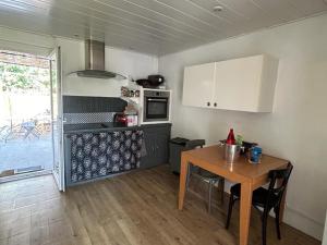 una cocina con mesa de madera y una cocina con armarios blancos. en Maison Elne, 5 pièces, 10 personnes - FR-1-732-60 en Elne