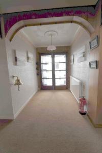 an empty hallway with a door and a window at Sandwick Bay Guest House in Stornoway