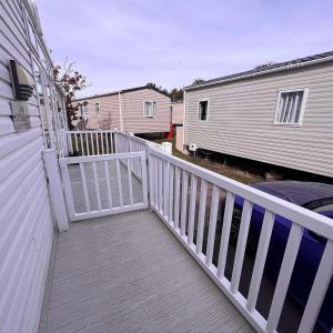 a white porch with a white railing next to a house at 3 bedroom luxury caravan haven, marton mere in Blackpool