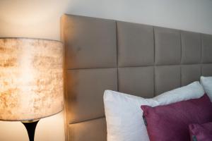 a bedroom with a bed with a headboard and a lamp at Ferienwohnungen im Stadtzentrum -JUNIK Apartments in Krefeld