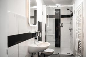 a bathroom with a sink and a toilet and a shower at Ferienwohnungen im Stadtzentrum -JUNIK Apartments in Krefeld