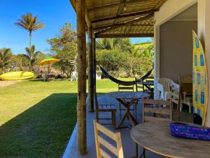 a patio with a table and chairs and a hammock at Beira Mar Meaipe Apt 1Q c/ lazer in Guarapari