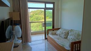 sala de estar con sofá y ventana grande en De frente pro mar em Cabo Frio, en Cabo Frío