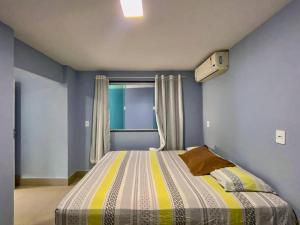 a bedroom with a large bed with a window at Beira Mar Meaipe Apt 1Q c/ lazer in Guarapari