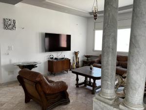 ein Wohnzimmer mit Ledermöbeln und einem TV in der Unterkunft Villa Olympus - Monastir 