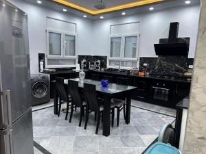 eine Küche mit einem schwarzen Tisch und schwarzen Geräten in der Unterkunft Villa Olympus - Monastir 