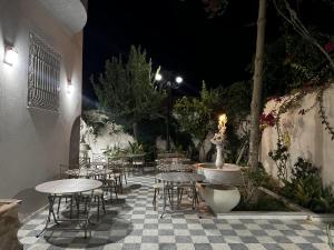 eine Außenterrasse mit Tischen und Stühlen in der Nacht in der Unterkunft Villa Olympus - Monastir 