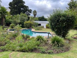 - une piscine dans une cour avec une maison dans l'établissement The Cottage on West, à Greyton