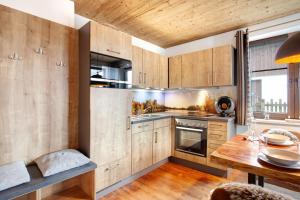 a kitchen with wooden cabinets and a wooden table at Bergchalet 20 in Diemelsee