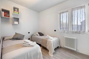 1 dormitorio con 2 camas y ventana en Casa Caterina, en Finale Ligure