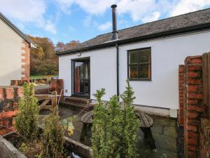 uma casa branca com um jardim em frente em Meadow View em Mold