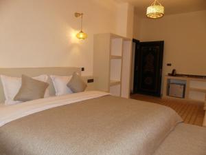 a bedroom with a large bed with white pillows at Riad La Luna in Merzouga
