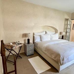 - une chambre avec un grand lit et une table de chevet dans l'établissement Dar Mayshad, à Rabat