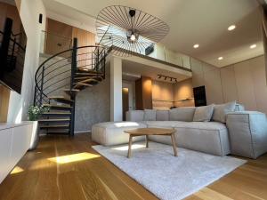 - un salon avec un canapé et un escalier en colimaçon dans l'établissement Molo Lipno apartmán B232, à Lipno nad Vltavou
