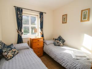 a bedroom with two beds and a window at Alyn View in Llanferres