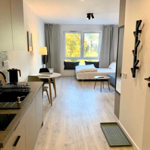 uma cozinha e sala de estar com um sofá e uma mesa em Platon Residence Apartments em Lódź