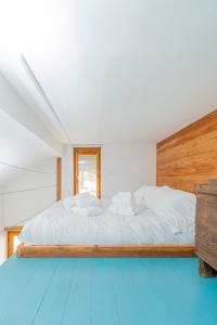 a bedroom with a large white bed with a wooden headboard at Chalet Palù in Brosso