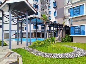 a building with a swimming pool in front of it at Sun Sky by Evernent in Miri