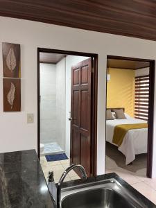 een badkamer met een wastafel en een slaapkamer met een bed bij Mevak Apartments Suites in Fortuna