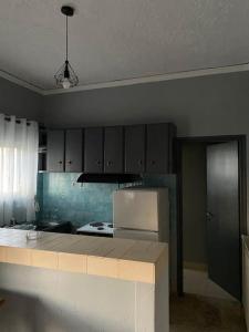 a kitchen with a stove and a refrigerator at Akrata Studio in Akrata