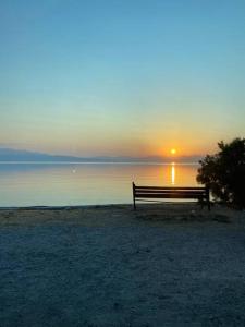a bench sitting in front of the ocean at sunset at Akrata Studio in Akrata