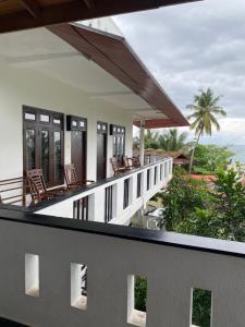 a balcony of a house with chairs and the ocean at Unawatuna Beach Bungalow - in Unawatuna