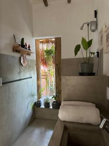 a room with a bench with potted plants and a window at Casa Chão in Prado