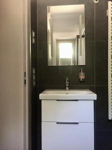 W łazience znajduje się biała umywalka i lustro. w obiekcie Alte Tischlerei Engelsbach w mieście Georgenthal