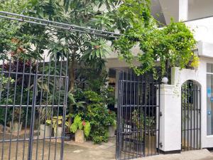 an iron gate in front of a building with trees at Unawatuna Beach Bungalow - in Unawatuna