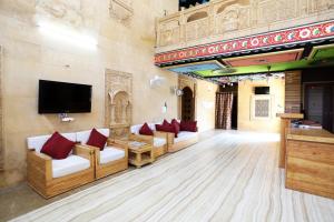 a living room with couches and a flat screen tv at Hotel Rana jaisalmer in Jaisalmer