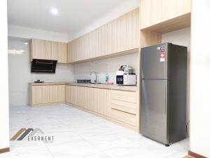 a kitchen with a stainless steel refrigerator and wooden cabinets at Sun Sky by Evernent in Miri
