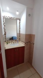 a bathroom with a sink and a mirror at El Depto de Roberto in Villa María