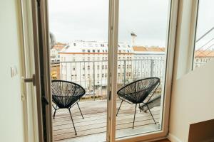 two chairs on a balcony with a view of a city at Large Apartments - Great for Groups - with Balcony or Terrace in Vienna