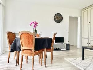 un comedor con una mesa con un jarrón de flores. en Appartement 2 pièces proche Enghien-Les-Bains, en Soisy-sous-Montmorency