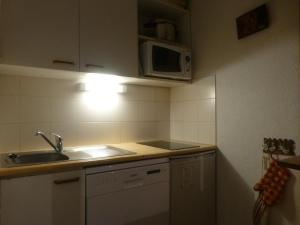 uma pequena cozinha com um lavatório e um micro-ondas em Appartement Peisey-Vallandry, 2 pièces, 5 personnes - FR-1-757-96 em Landry